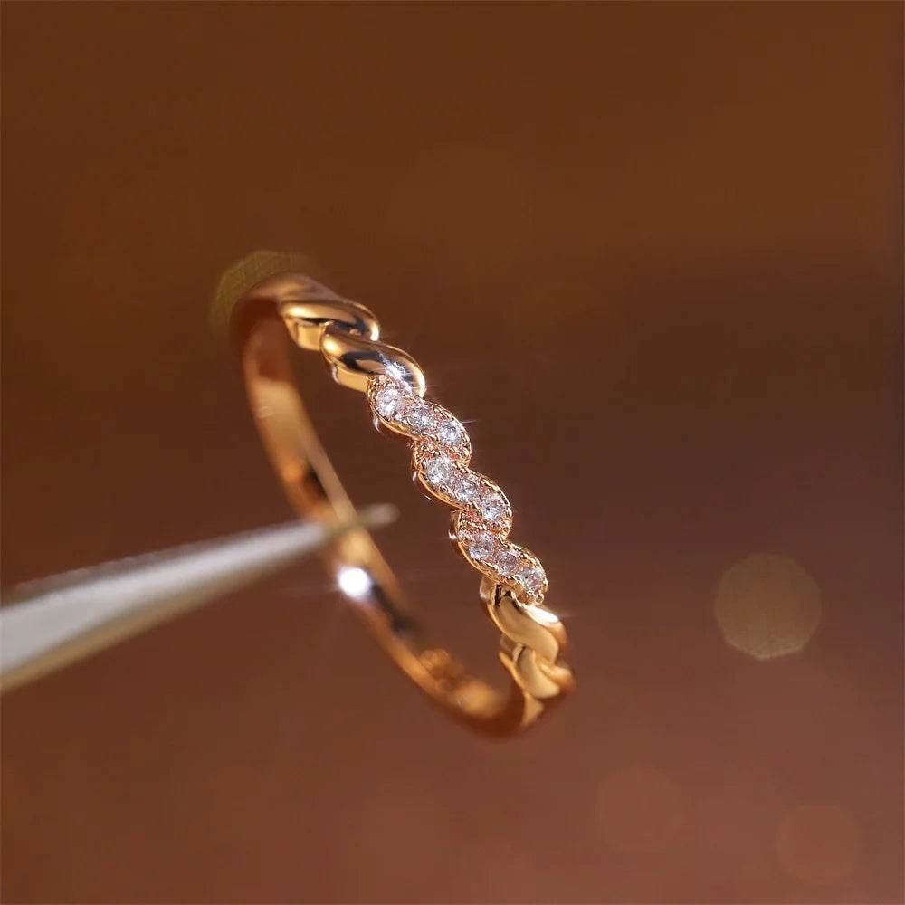 Delicate minimalist gold ring with small diamonds by Jewelrieshub on a warm brown background