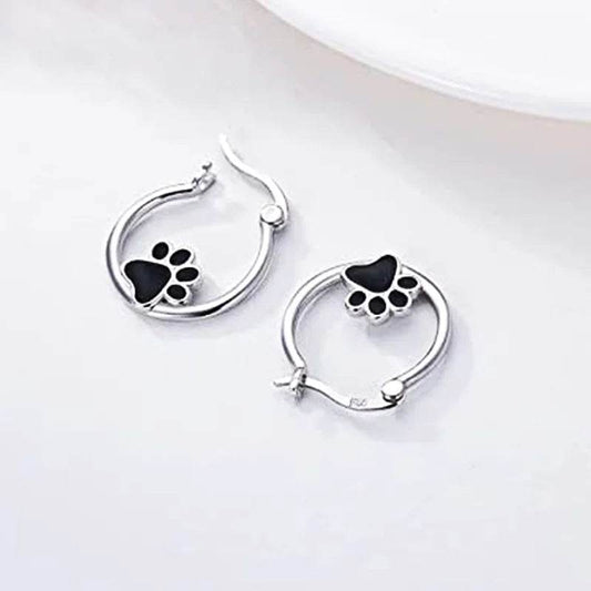Silver cat claw hoop earrings with black paw design on a white background